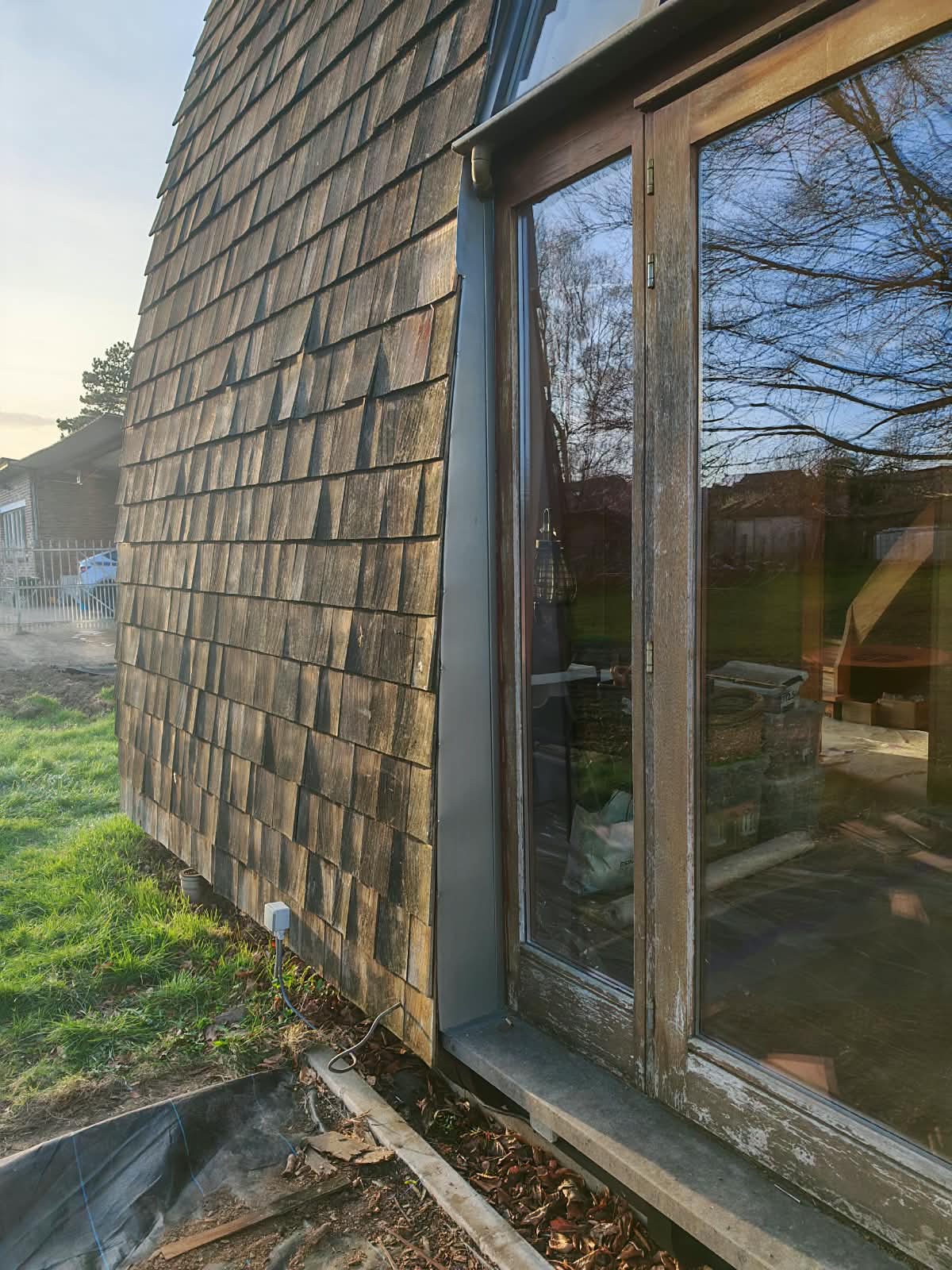Vue d'ensemble après réparation et étanchéité de la toiture : bardage en bois et raccords remis à neuf, finition propre et durable