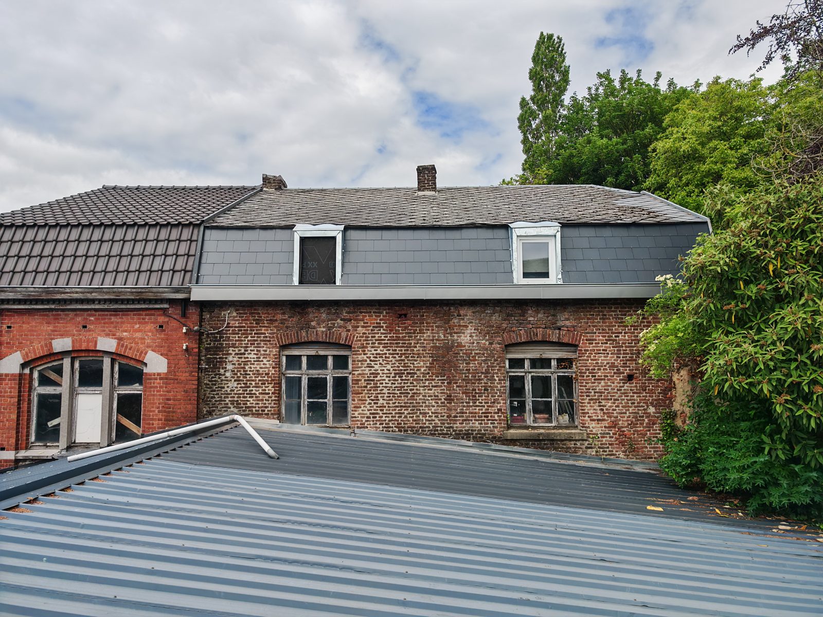 Vue d'ensemble d'une toiture rénovée avec lucarnes et zinguerie neuve par SkySafe Toitures, province de Liège