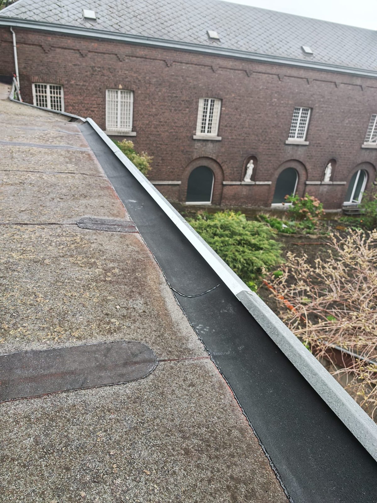 Corniche et toiture plate étanchée sur un long bâtiment, réalisation SkySafe Toitures près de Liège
