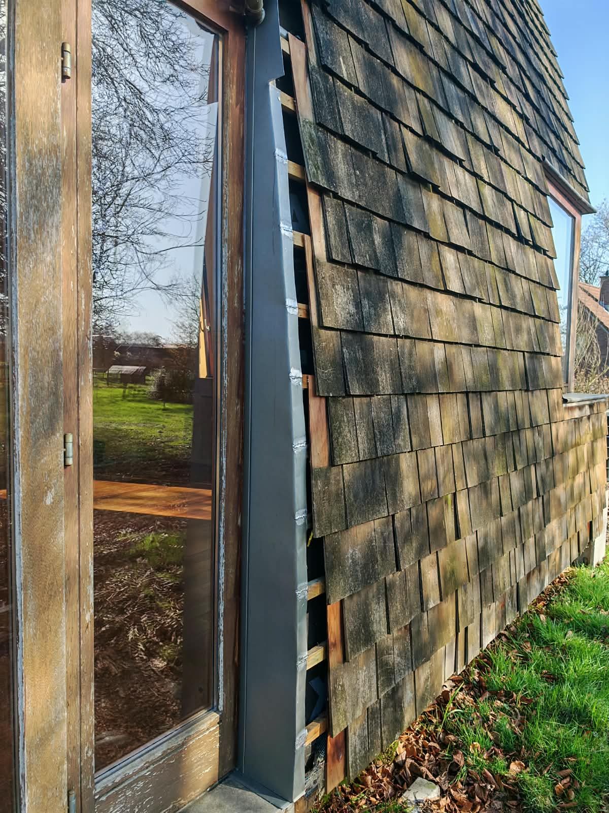 Bardeaux de bois déposés laissant la structure à nu lors d'un chantier de bardage SkySafe Toitures